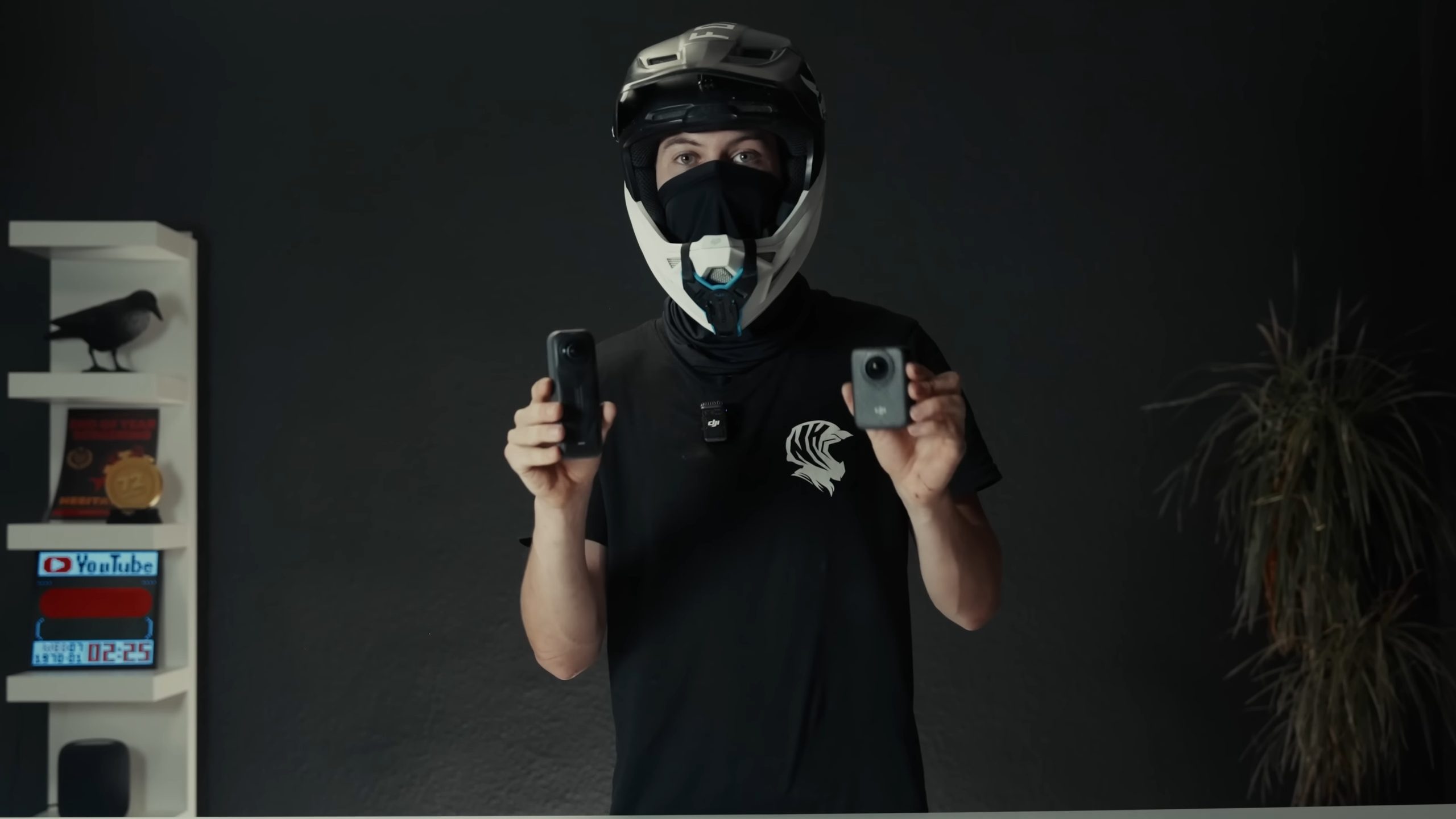 Presenter in a mountain bike helmet holding two action cameras